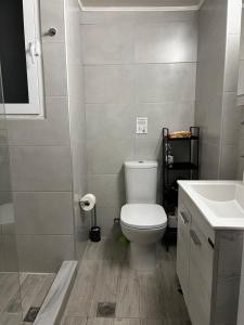 Łazienka z białą toaletą i umywalką w obiekcie Popi's Place w mieście Rodos
