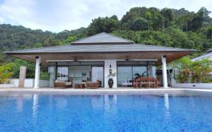 a pavilion with a pool in front of a house at Kulraya Villas - Luxury Serviced Pool Villas (A) in Ko Lanta
