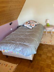 sypialnia z łóżkiem i stołem z lampą w obiekcie entre vignes et montagnes chambres w mieście Fréland