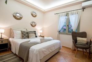 a bedroom with a bed and a chair and a window at The courtyard in Skala Eresou