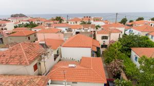 a town with orange roofs and the ocean at The courtyard in Skala Eresou