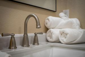 a bathroom sink with towels and a faucet at Peaceful Home with Nature Views & Trail Access in Yucca Valley