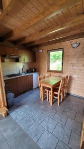 una cucina con tavolo e sedie in una stanza di domki nad jeziorem a Wołkowyja