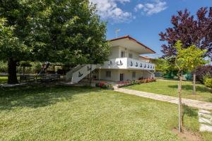 a large white house with trees and a yard at Spacious seaside house in Nea Potidaea