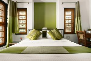 a bedroom with a large bed with green walls at Laika Boutique Stay in Bangalore