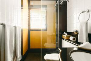 a bathroom with a shower and a sink and a toilet at Laika Boutique Stay in Bangalore