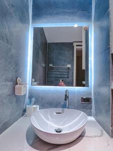 ein Badezimmer mit einem weißen Waschbecken und einem Spiegel in der Unterkunft Alula Sweet Home in Hanoi