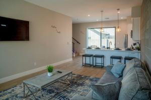 ein Wohnzimmer mit einem Sofa und einem Tisch sowie eine Küche in der Unterkunft Clarendon Lux Modern Townhome in Phoenix