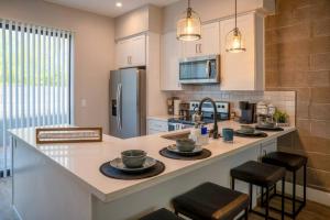 eine Küche mit einer Theke mit Hockern und einer Arbeitsplatte in der Unterkunft Clarendon Lux Modern Townhome in Phoenix