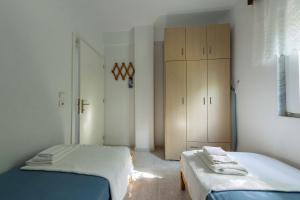 a bedroom with two twin beds and a closet at Spacious seaside house in Nea Potidaea