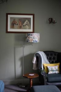 ein Wohnzimmer mit einem Sofa und einem Tisch mit einer Lampe in der Unterkunft Braithwaite Hall Apartment in East Witton