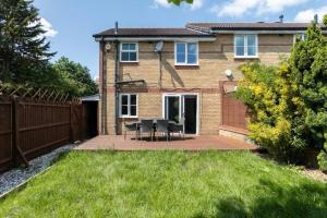 a house with a table and chairs in the yard at Lovegrove House - Modern 3 bed house for business or family stay with free parking in Slough