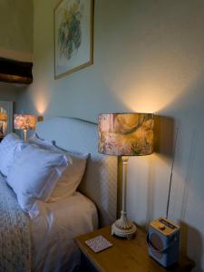 a bedroom with a bed and a lamp on a table at Braithwaite Hall Apartment in East Witton