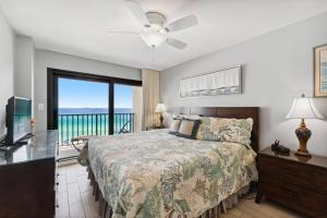 a bedroom with a bed and a view of the ocean at Commodore 609 in Panama City Beach