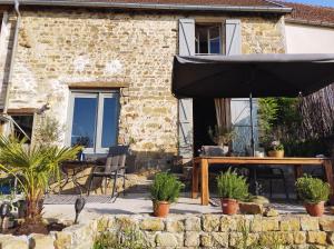 a patio with an umbrella and a table and chairs at Chateau d'Impasse in Laferté-sur-Amance