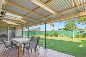 eine Terrasse mit Tisch und Stühlen unter einer Pergola in der Unterkunft Crestmead Cottage in Kingston + 3 Fotos