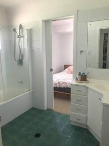 ein Badezimmer mit einem Waschbecken und ein Schlafzimmer mit einem Bett in der Unterkunft Crestmead Cottage in Kingston