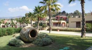 a sculpture in a park with palm trees and buildings at Villa Valentina in Estepona