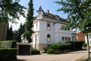 una grande casa bianca con torretta di Ferienwohnung Villa Radau a Bad Harzburg