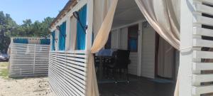 a porch with a table and curtains on a house at Mobile Homes Inalex Relax in Privlaka