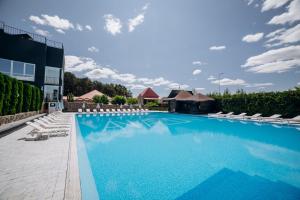 a large swimming pool with lounge chairs and a building at Avalon Hotel&Pool in Yelikhovichi