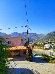 a building next to a beach with mountains in the background at Galini Apartments in Balíon