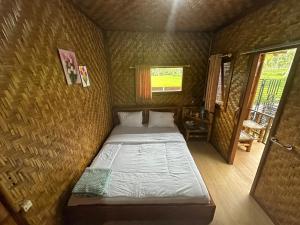 a small bedroom with a bed in a room at Mysha Guest House-Lombok in Tetebatu