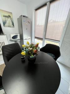 Una mesa negra con un jarrón de flores. en Луксозен двустаен в Балчик с морска гледка en Balchik