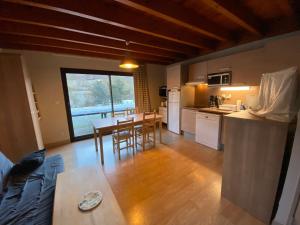 cocina y sala de estar con mesa y sillas en Appartement en duplex pour 8 personnes en Arreau