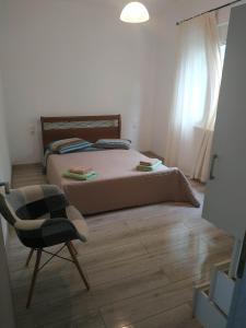 1 dormitorio con 1 cama, 1 silla y 1 ventana en Дом для дружной семьи, en Mikros Gialos