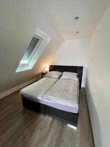 a bedroom with a large bed with a skylight at FeWo Eich im Emsland in Langen