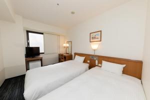 a hotel room with two beds and a television at Nara Washington Hotel Plaza in Nara