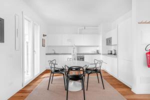 a white kitchen with a table and chairs at Modern with Terrace & Garage - NDP Rent in Milan