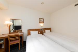 a hotel room with two beds and a desk and a mirror at Nara Washington Hotel Plaza in Nara +15 photos