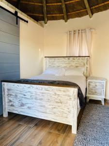a bedroom with a large bed with a wooden headboard at Seqonoka Villa Accommodation & Events Park in Berea Hills