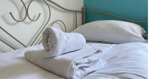un mucchio di asciugamani bianchi seduti sopra un letto di Sherlock's Holidays boutique rooms a Portoroz