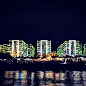 un gruppo di edifici illuminati di notte di Beach Resort Studio Fitness-spa-pool a Mamaia Nord - Năvodari