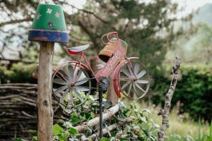 uma pequena bicicleta vermelha num poste de madeira com um top verde em Ferienwohnungen Baumann-Breitenberg em Sankt Georgen am Reith