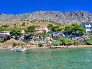 a view of a beach with a boat in the water at At Jenny in Omiš