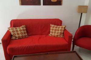 eine rote Couch und ein roter Stuhl in einem Zimmer in der Unterkunft Precioso apartamento junto a plaza la Corredera in Córdoba
