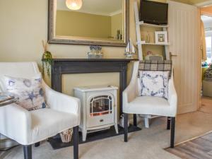 a living room with two chairs and a fireplace at Sams Snug in Birchington