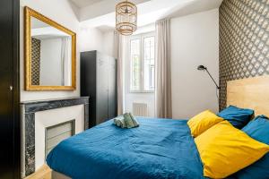 a bedroom with a blue bed and a fireplace at Plein centre avec "PARKING PRIVE" Voitures électriques bienvenues in Cassis