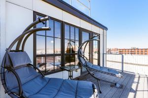 a room with a chair and a table on a balcony at CozySuites Spacious 2BR penthouse w Skyline view in Saint Louis