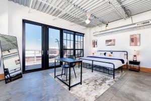 a bedroom with a bed and a table at CozySuites Spacious 2BR penthouse w Skyline view in Saint Louis