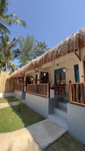 吉利阿尔Formosa Beach Club & Bungalow的茅草屋顶和楼梯的房子