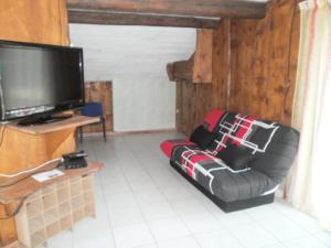 a living room with a couch and a flat screen tv at Hotel Restaurant Lancheton in Saint-Julien-Mont-denis