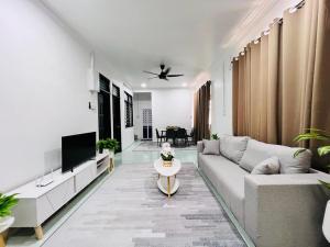 a living room with a couch and a tv at HOMESTAY TOK ABAH in Kuala Berang