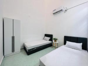 um quarto com duas camas e uma cómoda em HOMESTAY TOK ABAH em Kuala Berang