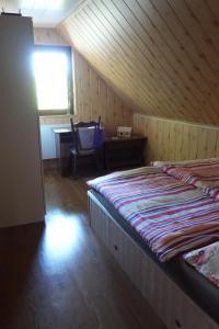 1 dormitorio con 2 camas, escritorio y ventana en Pod Lípou, en Dolní Brusnice
