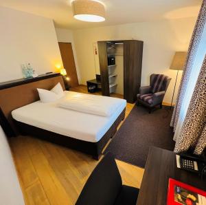 バート・テルツにあるポストホテル コルバブロイのベッドと椅子付きのホテルルーム